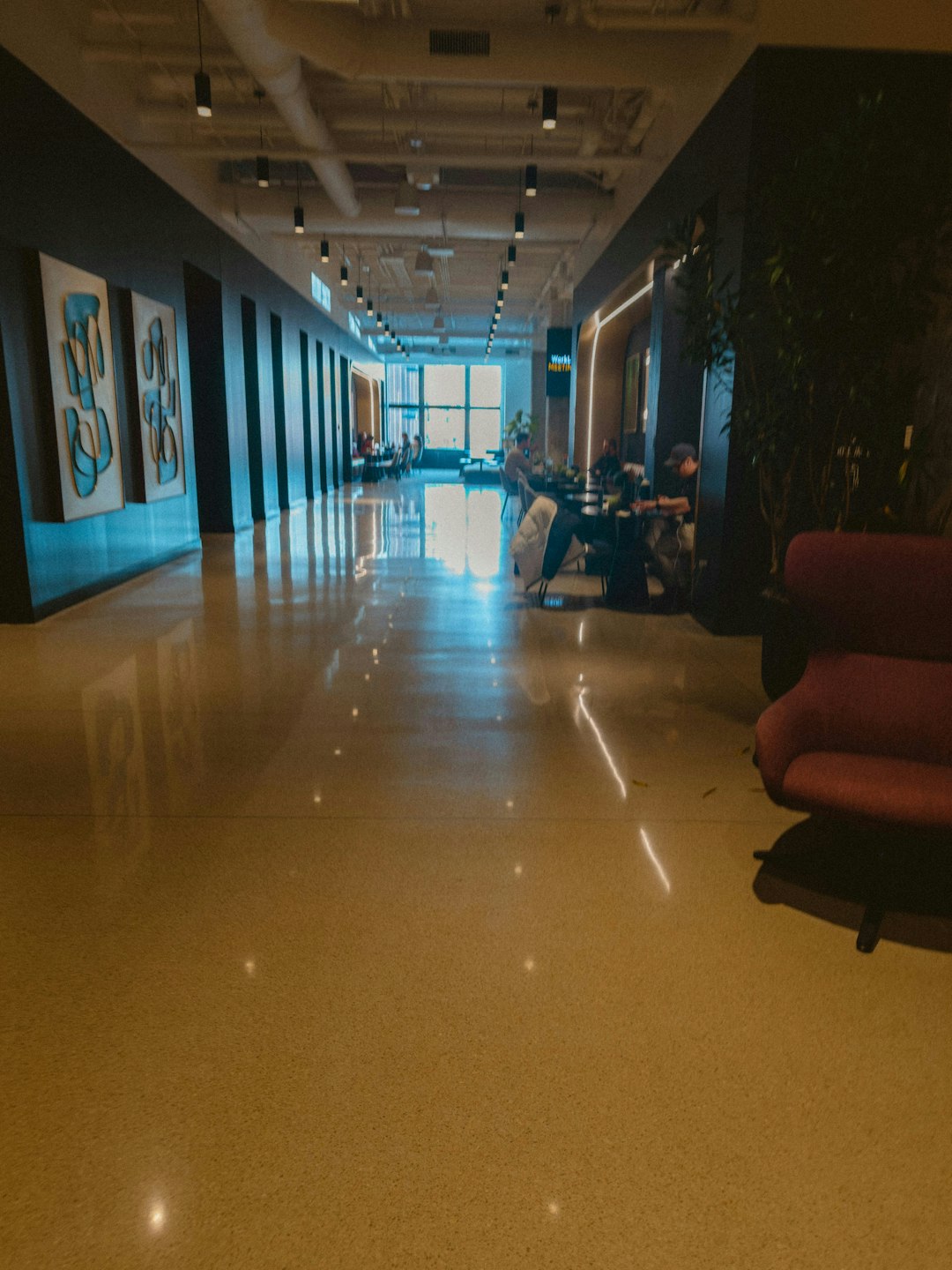 A dark hallway with people working at desks